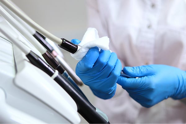 Disinfection of dental equipment. A dental assistant disinfects instruments before receiving patients.