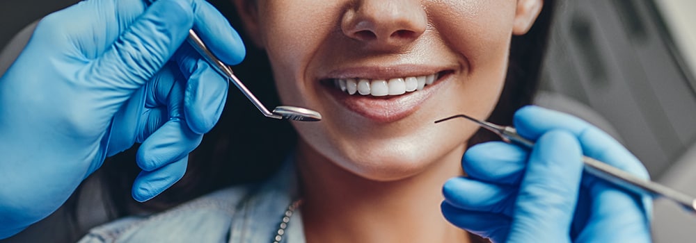 dentist and smiling patient in modern dental office